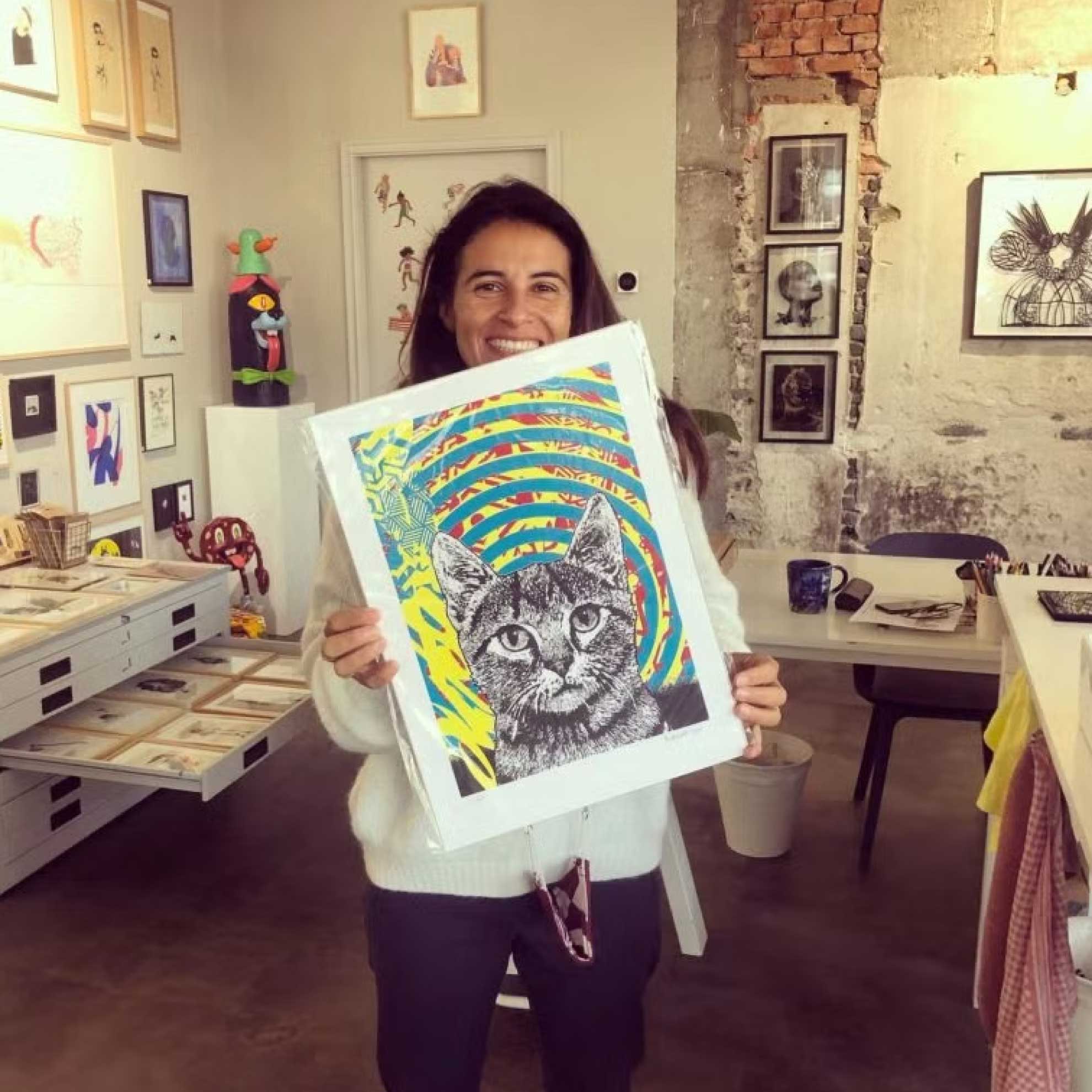 Owner of the Nook Gallery in the Hague holding a silkscreen print by Studio Daboo